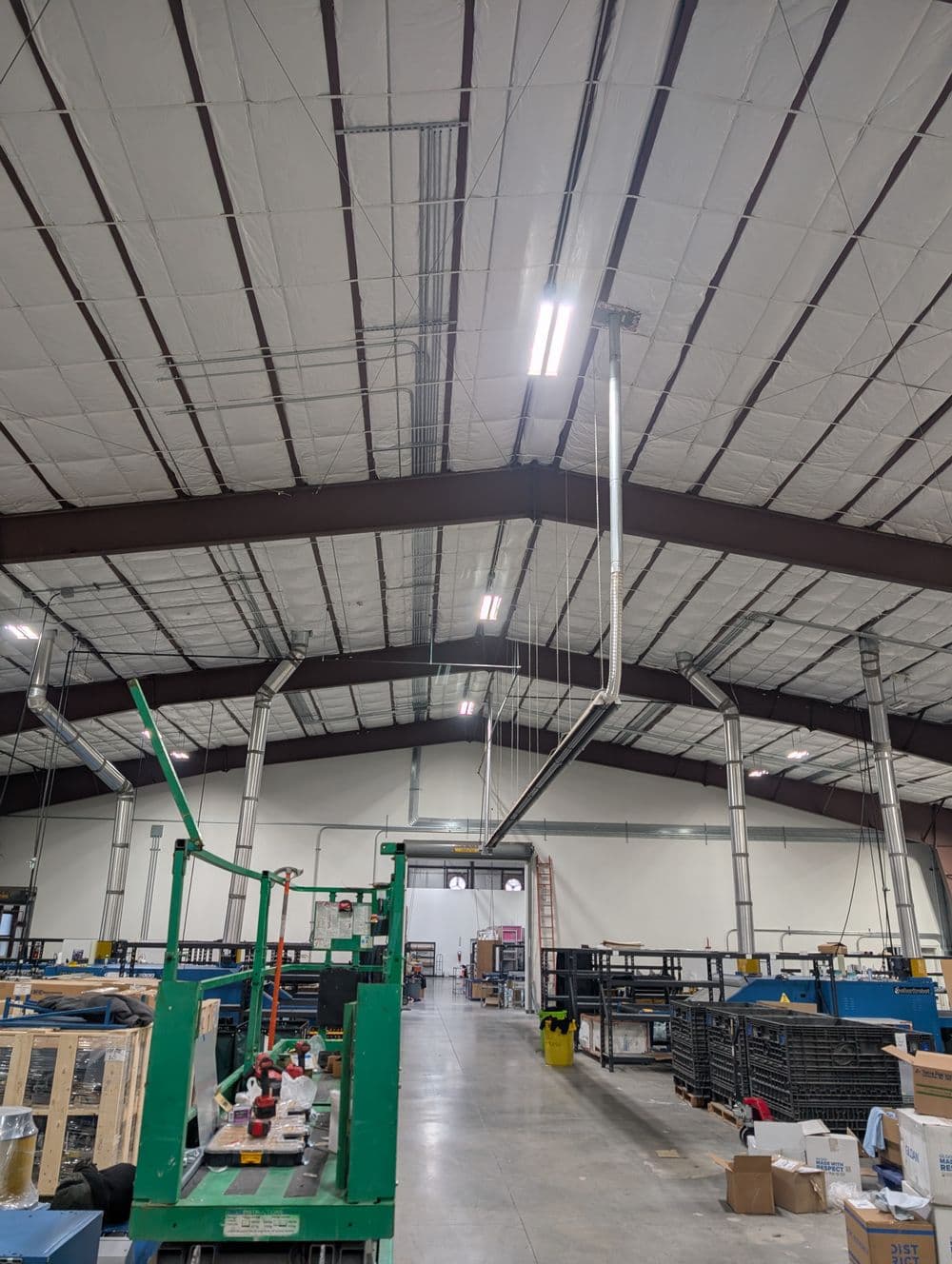 Interior of a spacious warehouse with high ceilings, shelves, and industrial equipment.