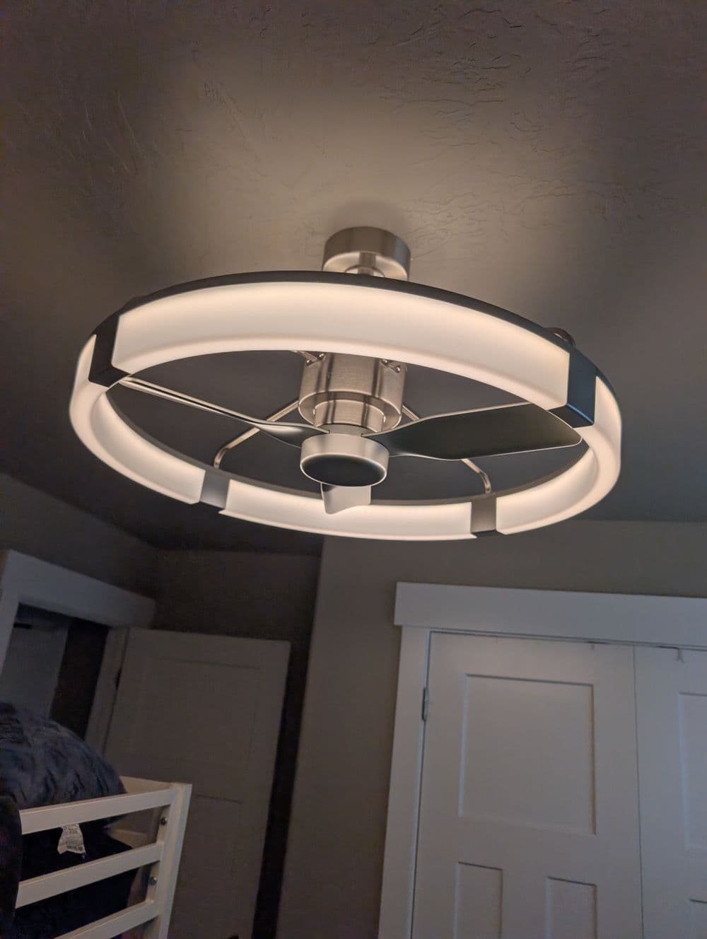 Modern ceiling fan light fixture with circular design and integrated LED lights.